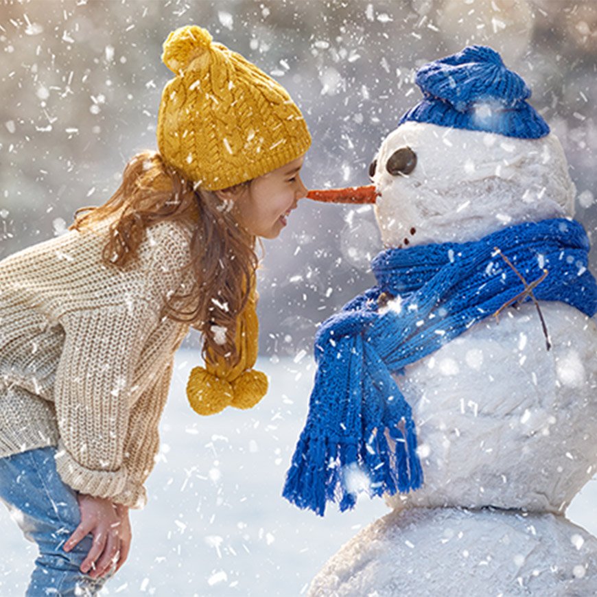 girl nose to nose with snowman